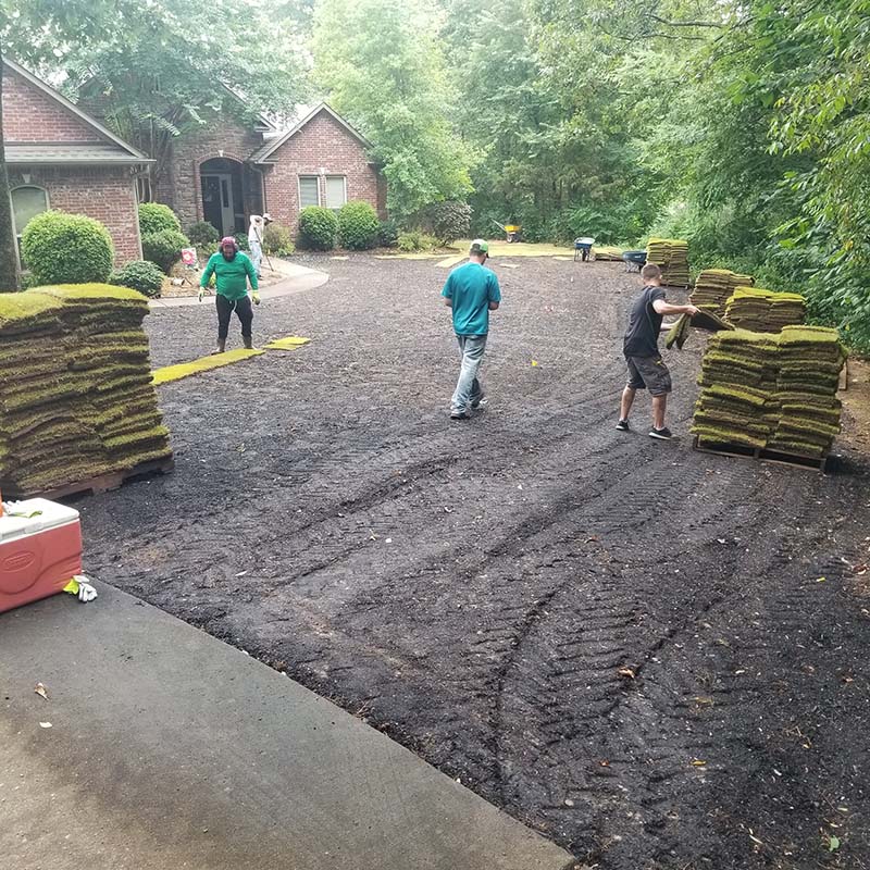 landscape professionals working in front of brick home
