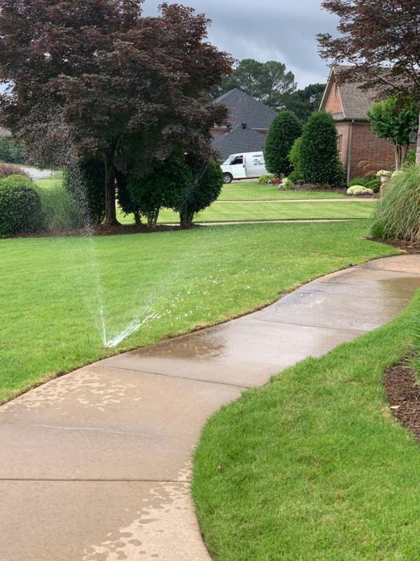 sidewalk in front residential home with sprinkler service