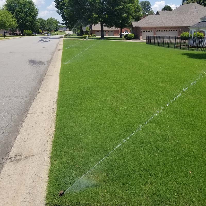 sprinkler system spraying residential lawn
